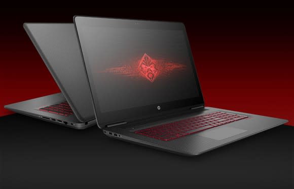 Picture of two HP OMEN laptops open on a table back to back.