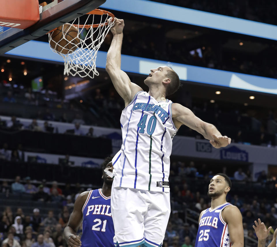 Charlotte Hornets' Cody Zeller (40) dunks against Philadelphia 76ers' Joel Embiid (21) during the first half of an NBA basketball game in Charlotte, N.C., Saturday, Nov. 17, 2018. (AP Photo/Chuck Burton)
