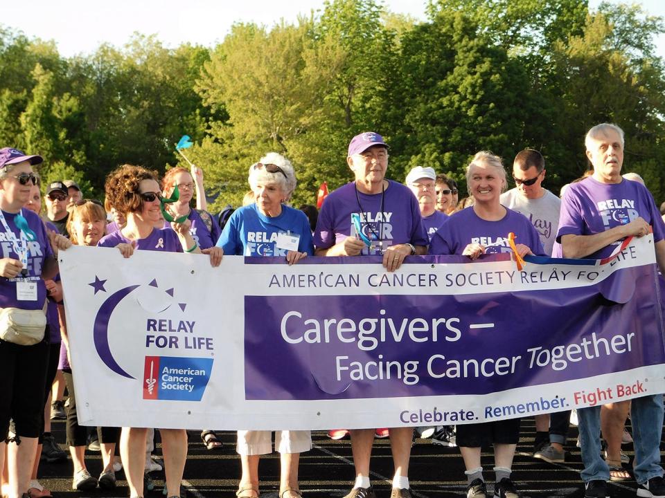 Participants carry the Relay for Life banner during the 2019 event's opening lap for survivors and caregivers at Mount Wachusett Community College in Gardner.