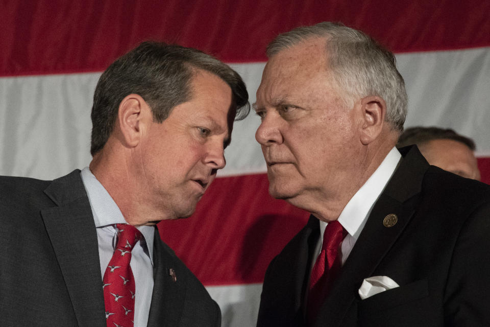 Georgia Secretary of State and Republican gubernatorial nominee Brian Kemp, left, talks to outgoing Gov. Nathan Deal during a unity rally, Thursday, July 26, 2018, in Peachtree Corners, Ga. (AP Photo/John Amis)