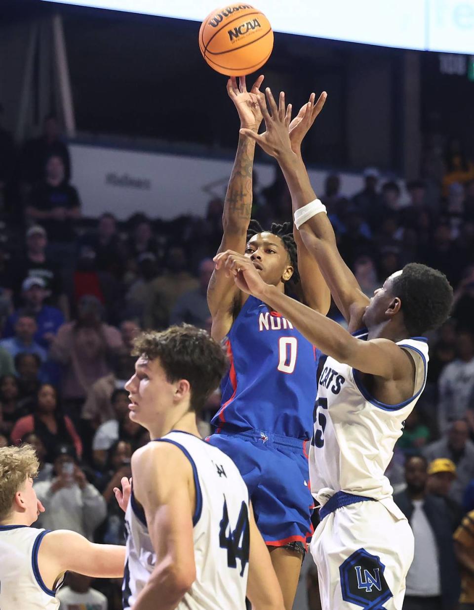 North Meck’s Isaiah Evans, center, releases a two-point basket in the closing seconds of fourth quarter action against Lake Norman in the AAAA Regional Championship on Thursday, March 14, 2024 at Lawrence Joel Veterans Memorial Coliseum in Winston-Salem, NC. North Meck defeated Lake Norman 65-61. JEFF SINER/jsiner@charlotteobserver.com