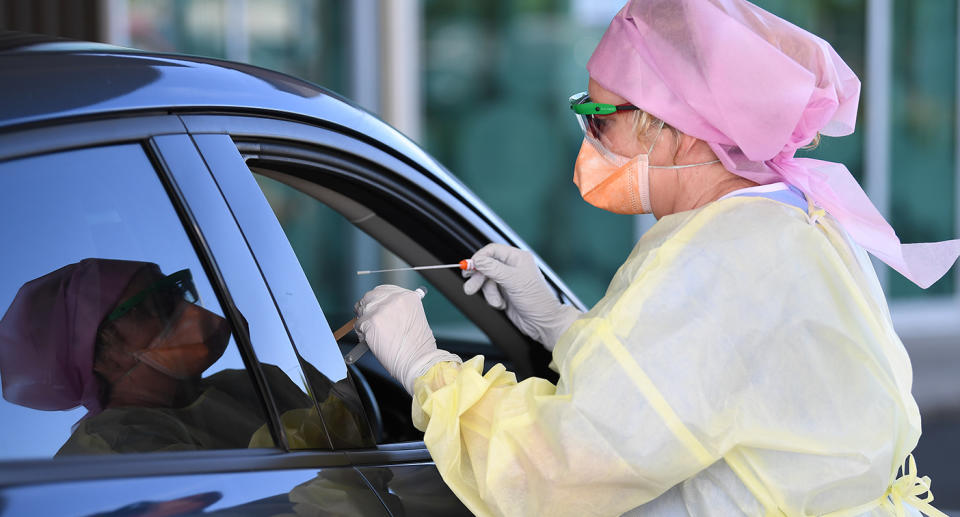 Nurse Shirley Molloy swabs a patient for COVID-19 at a drive-through Fever Clinic on the Sunshine Coast