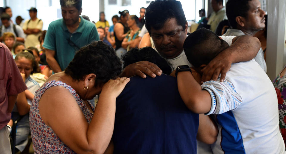 Family of victims killed in Mexican bar fire shown in emotional embrace.