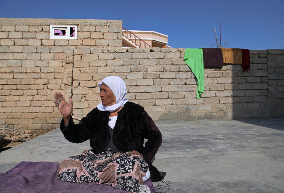 A Yazidi woman Farso Mato Sabo, 89, a survivor of Islamic State atrocities recounts her harrowing tale in the village of Tal Binat, Sinjar, Iraq. Friday Dec. 4, 2020. A new agreement aims to bring order to Iraq's northern region of Sinjar, home to the Yazidi religious minority brutalized by the Islamic State group. Since IS's fall, a tangled web of militia forces have run the area, near the Syrian border. Now their flags are coming down, and the Iraqi military has deployed in Sinjar for the first time in nearly 20 years. (AP Photo/Samya Kullab)