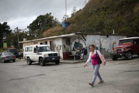 A woman walks past a public transport office in El Junquito, Venezuela, February 19, 2019. Picture taken February 19, 2019. To match Insight VENEZUELA-POLITICS/EVIDENCE. REUTERS/Andres Martinez Casares