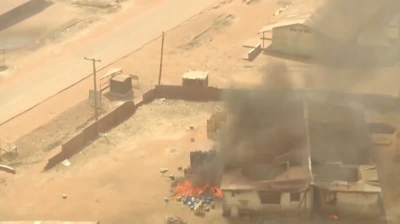 Smoke rises as objects burn next to a building amid a surge in violence in Mangu