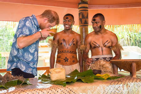 Britain's Prince Harry smells a bowl of kava as he views a demonstration of kava making by Joeli Nasqqa (centre) and Eparama Uluiuiti (right) at a dedication of the Colo-i-Suva forest to the Queen's Commonwealth Canopy in Suva, Fiji, October 24, 2018. Dominic Lipinski/Pool via REUTERS