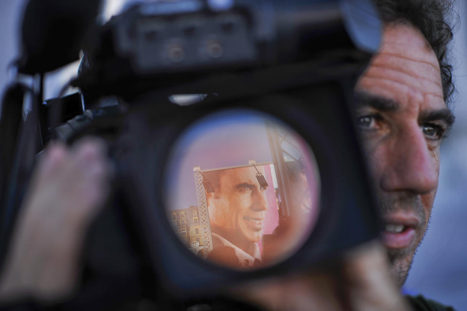 The portrait of U.S. actor John Travolta, one Award of San Sebastian Film Festival, is reflected in the lens of a camera , a day before the beginning of the 60th San Sebastian Film Festival Cinema in San Sebastian, northern Spain, Thursday Sept. 20, 2012. The San Sebastian Film Festival, the oldest and most prestigious in the Spanish speaking world, opens tomorrow with a strong focus on European and American movies. (AP Photo/Alvaro Barrientos)