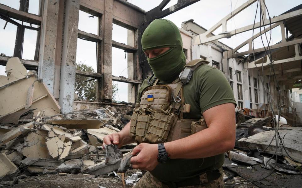 A Ukrainian serviceman holds rocket fragments at the ruins of the sports complex of the National Technical University in Kharkiv, Ukraine, Friday, June 24, 2022, damaged during a night shelling. - AP Photo/Andrii Marienko