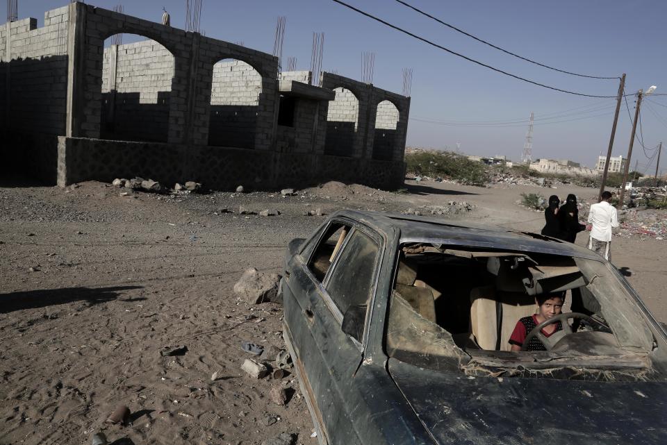 FILE - In this Feb. 10, 2018 file photo, a boy sits in a damaged car in Mocha, Yemen. Envoys from Yemen’s warring parties are headed to Sweden for another round of peace talks to stop the three-year-old war, but with few incentives to compromise, expectations are low for little more than improving a faltering de-escalation. (AP Photo/Nariman El-Mofty, File)