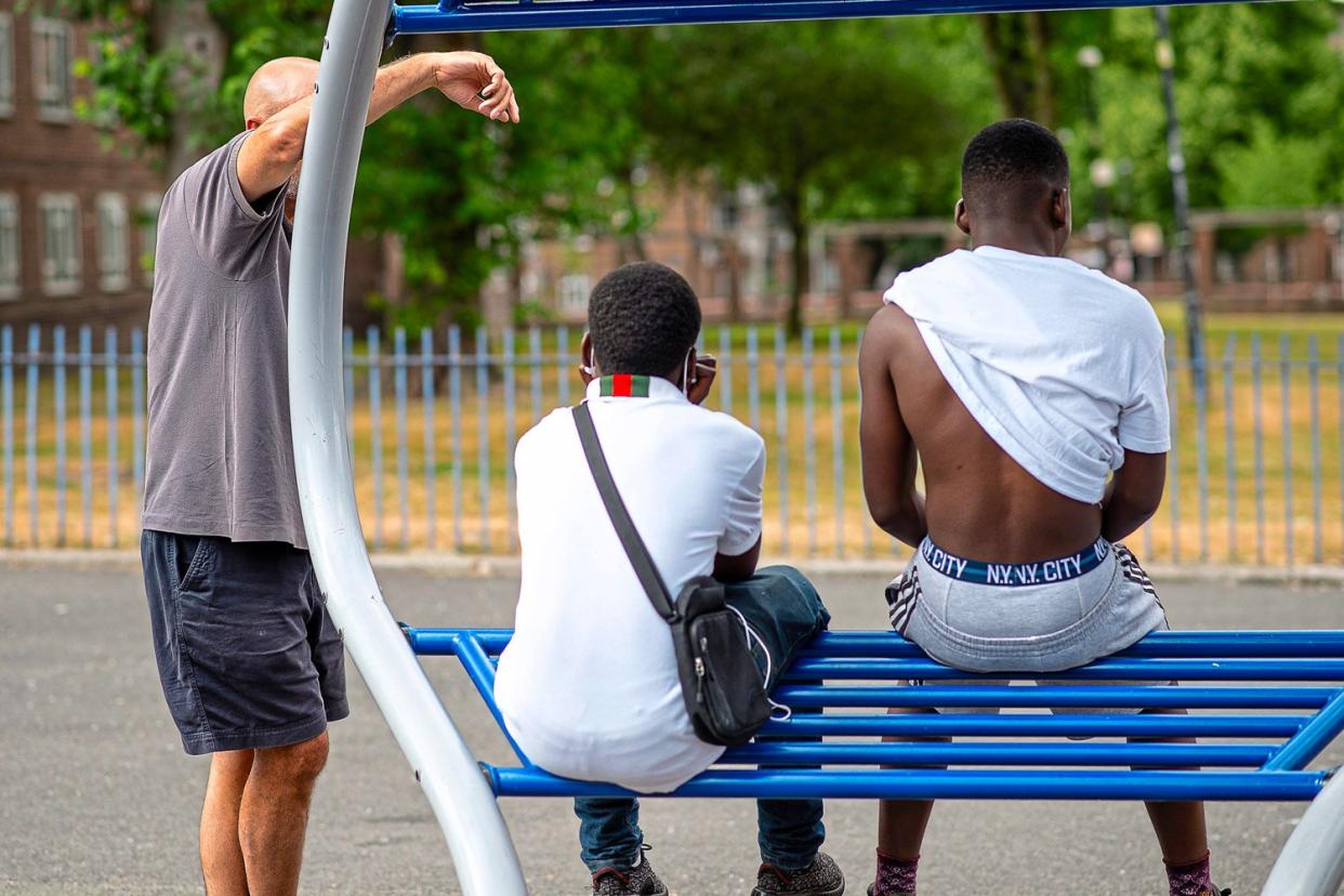 Trusted voice: Lee Dema, far left, founder of charity the St Matthew’s Project, talks to young people on Tulse Hill estate: Daniel Hambury