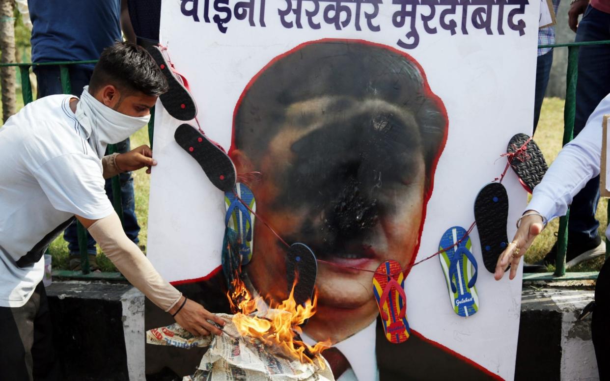 Activists of Bharatiya Janta Party's (BJP) Youth Wing shout slogans as they burn a portrait of Chinese President Xi Jinping - RAMINDER PAL SINGH/EPA-EFE/Shutterstock /Shutterstock