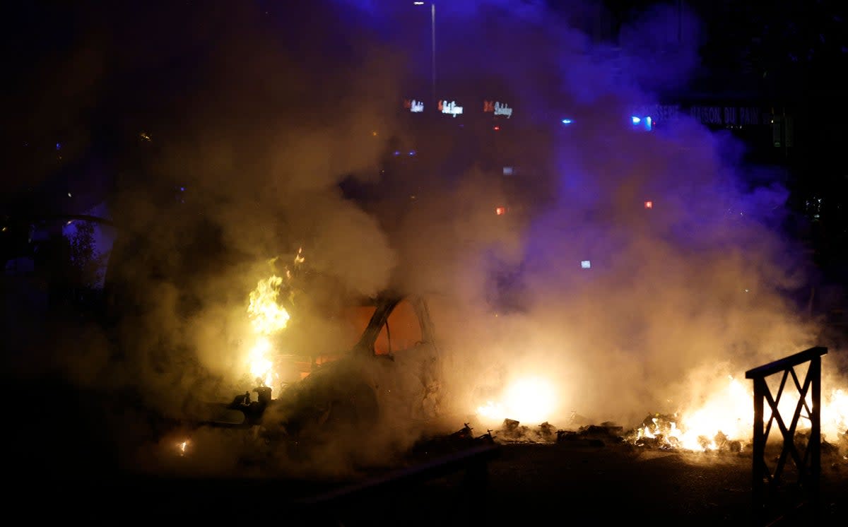 Smoke rises from a car set ablaze during protests in Nanterre, west of Paris, on the early hours of 29 June 2023 (AFP via Getty Images)