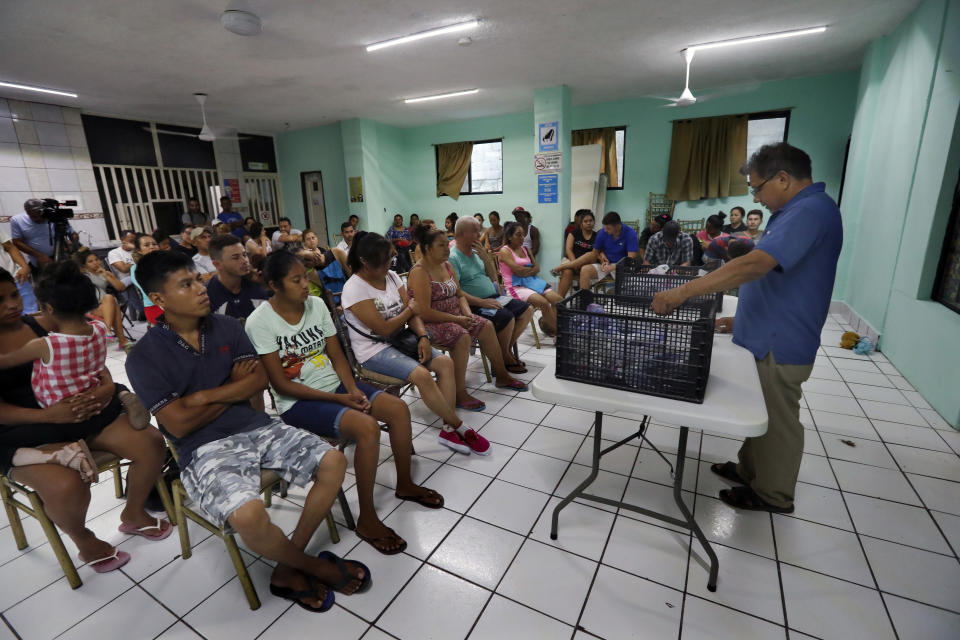 In this July 17, 2019 photo, Rev. Aaron Mendez talks with migrants at the AMAR migrant shelter, in Nuevo Laredo, Mexico. Officials in the Mexican border state of Tamaulipas say the pastor was abducted Aug. 3 from the shelter he ran in the dangerous border city of Nuevo Laredo. (AP Photo/Marco Ugarte)