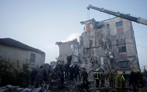 Emergency personnel work near a damaged building in Thumane, after an earthquake shook Albania - Credit: REUTERS