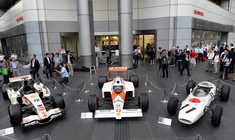 Three generations of Honda Formula One cars -- the 2006 Honda RA106 (left), the 1988 McLaren Honda MP4/4 (centre) and 1965 Honda RA272 -- on display in Tokyo, on May 16, 2013. Honda has said it will return to Formula One in 2015 as an engine supplier to British team McLaren in a bid to revive their championship-winning partnership