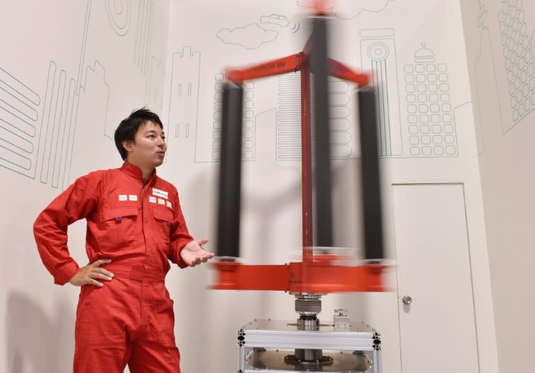 Engineer Atsushi Shimizu, founder and CEO of the Japanese venture company Challenergy, stands next to his bladeless wind turbine in Tokyo