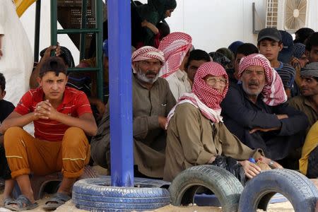 Syrian refugees wait to board a Jordanian army vehicle after crossing into Jordanian territory with their families, in Al Ruqban border area, near the northeastern Jordanian border with Syria, and Iraq, near the town of Ruwaished, 240 km (149 miles) east of Amman September 10, 2015. Picture taken September 10, 2015. REUTERS/Muhammad Hamed