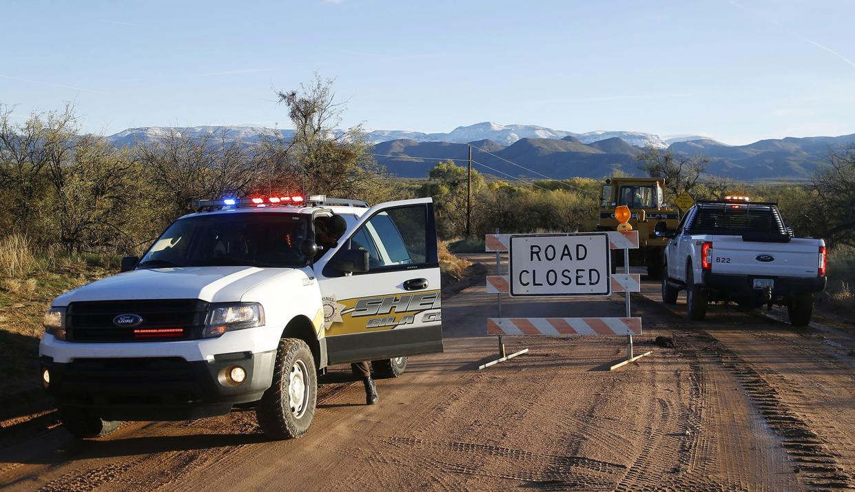 FILE - In this Nov. 30, 2019, file photo, a road is closed near Bar X road and Tonto Creek after a vehicle was washed away by floodwaters in Tonto Basin, Ariz. 