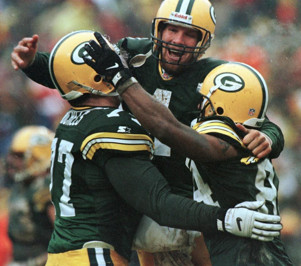 FILE - This Jan. 4, 1997, file photo shows Green Bay Packers, from left, John Michels, Brett Favre and Andre Rison celebrating after Green Bay's Antonio Freeman recovered a fumble by teammate Edgar Bennett for a touchdown in the third quarter against the San Francisco 49ers in Green Bay, Wisc. The Packers and 49ers that have combined for nine Super Bowl titles will meet with a spot in the ultimate game on the line once again when the 49ers (14-3) host the Packers (14-3) in the NFC championship game on Sunday, Jan. 19, 2020.(AP Photo/Morry Gash, file)