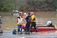 A baby being carried to safety by rescuers on Sunday morning. (PA)