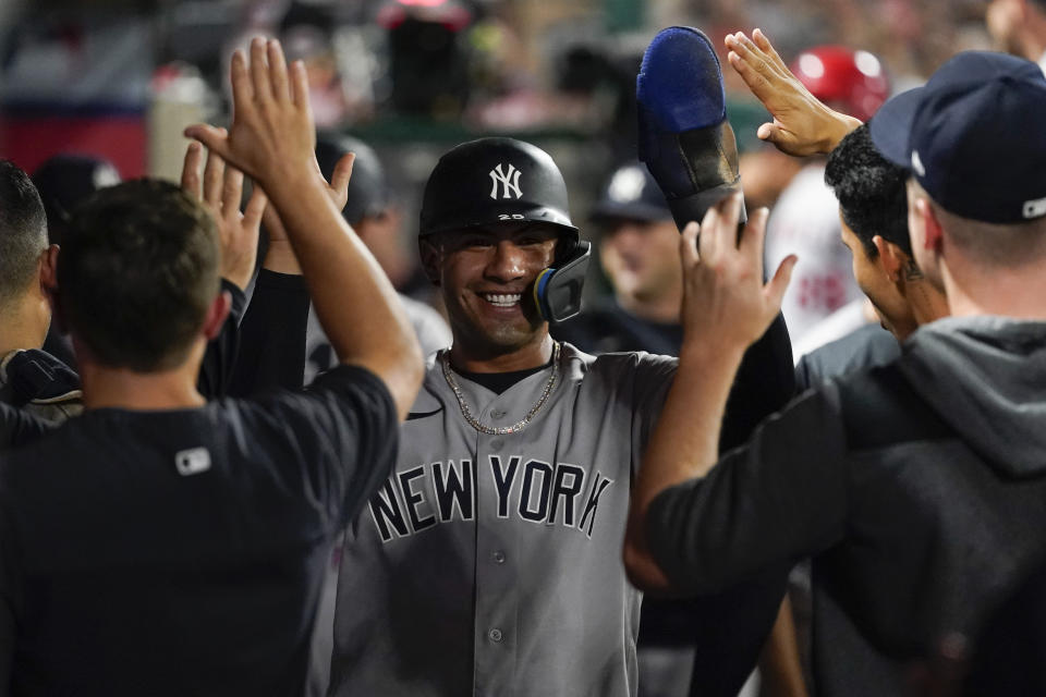 New York Yankees' Gleyber Torres, center, celebrates with teammates in the dugout after scoring on a sacrifice fly hit by Aaron Hicks during the fifth inning of a baseball game against the Los Angeles Angels in Anaheim, Calif., Wednesday, Aug. 31, 2022. (AP Photo/Ashley Landis)