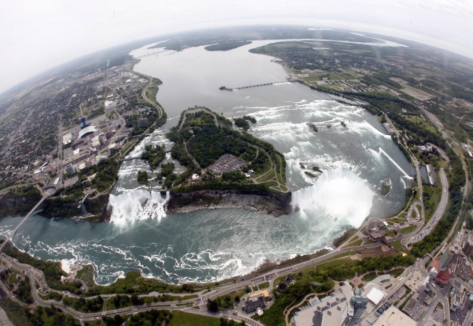 FILE - In this June 3, 2009 photo, Ruedi Hafen, not shown, president and chief pilot of Niagara Helicopters Ltd., flies over Niagara Falls in Niagara Falls, Ontario. In recent years, for economic reasons, Niagara Falls has thrown open its doors to casino gambling, gay weddings and a tightrope walk that, until laws were relaxed, would have meant arrest. It even briefly considered taking in toxic wastewater from hydraulic fracturing. On the drawing board now is a plan to entice young people to move in by paying down their student loans. (AP Photo/David Duprey, File)