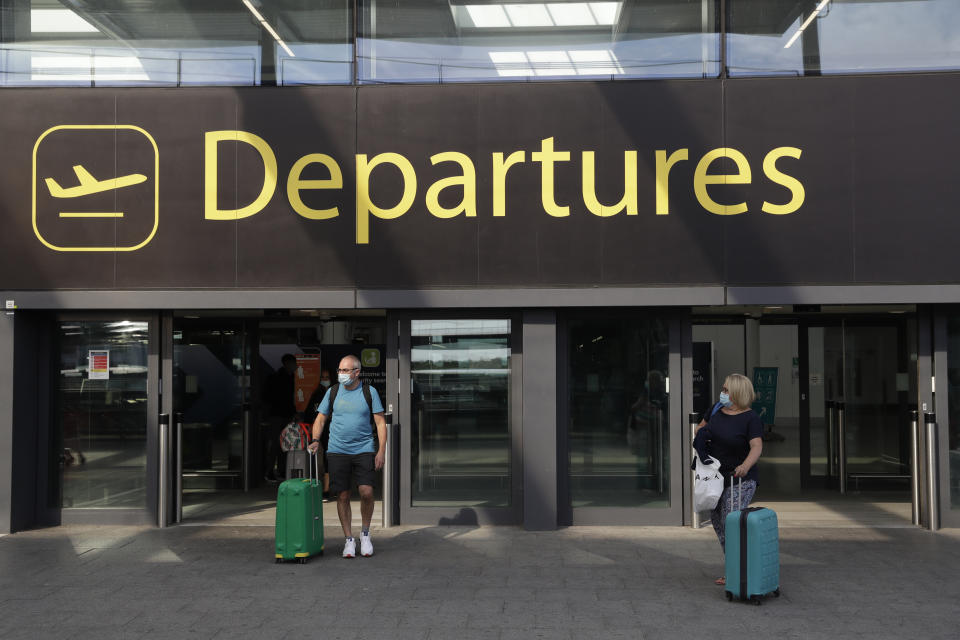 Passengers walk out of Departures, at the North Terminal of Gatwick Airport near Crawley, just south of London, Wednesday, July 22, 2020. With all schools now closed, Friday would normally be the busiest departure day of the year for London’s Gatwick Airport with families heading off to the sun-soaked beaches in southern Europe. Not this year as the coronavirus pandemic has meant many have opted against making their annual summer migration to countries like Spain and Greece. Gatwick would in any normal year be expecting to fly some 85,000 holidaymakers on Friday alone. It expects less than 10,000 passenger departures on Friday. (AP Photo/Matt Dunham)