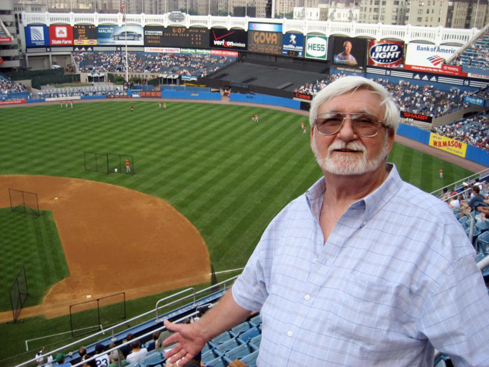 In this 2008 photo provided by John Pijanowski, Pijanowski's father Don Pijanowski, who died of COVID-19 on April 1, 2020, poses during his first visit to Yankee Stadium in New York. Unable to be with their father during his final moments, Pijanowski's sons asked a nurse at a hospital in Buffalo, N.Y., to tell him they loved him. (John Pijanowski via AP)