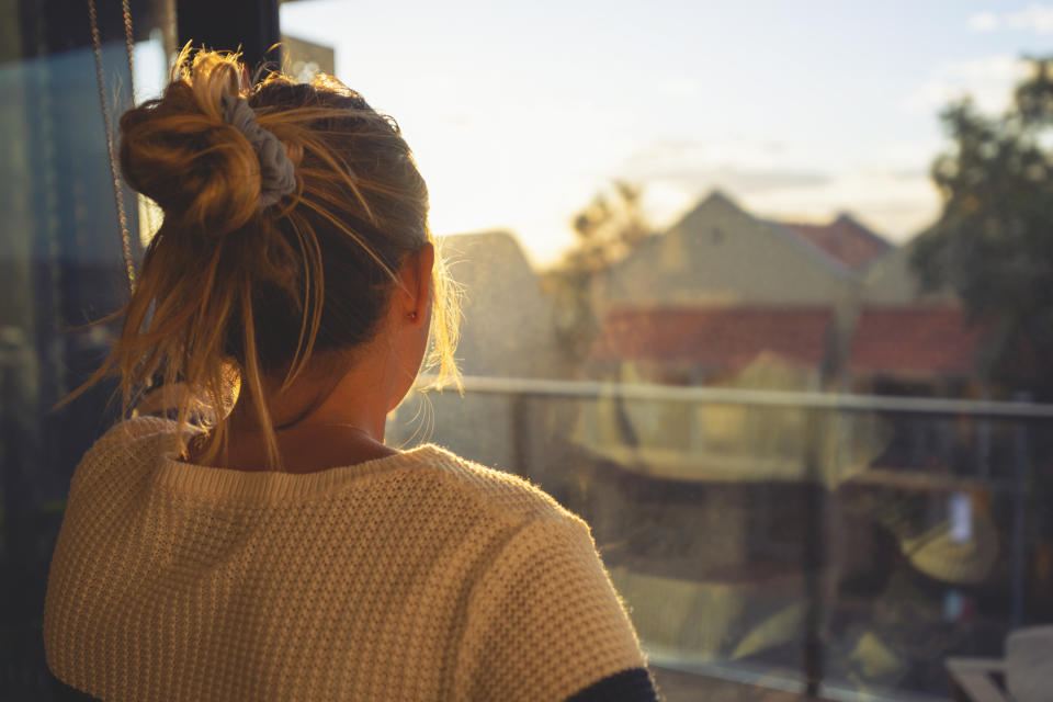 A young girl stares out the window. 