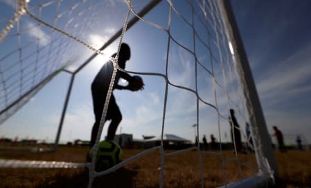 Immigrants play soccer at the U.S. government's newest holding center for migrant children in Carrizo Springs,