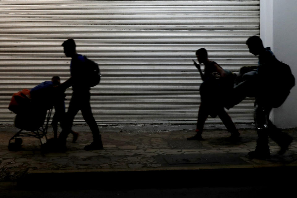 Migrant families camped in a park leave in the middle of the night as they are pushed out by Mexican immigration authorities, in Tapachula, Mexico, early Wednesday, May 29, 2019. Authorities cleared the park of camping Central American migrants and the makeshift encampment of Haitians and African migrants outside the immigration detention center near the Guatemala border. (AP Photo/Marco Ugarte)