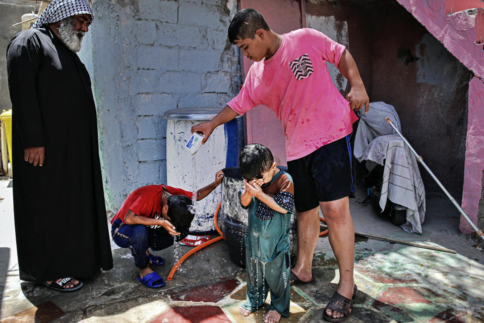 Children cool themselves with water during a power outage in Basra, Iraq, Tuesday, July 29, 2021. In Iraq, electricity is a potent symbol of endemic corruption, rooted in the country’s sectarian power-sharing system. This contributes to chronic electrical outages of up to 14 hours a day in a major oil-producing nation with plentiful energy resources. (AP Photo/Nabil al-Jurani)