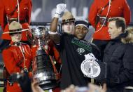 The Saskatchewan Roughriders Kory Sheets accepts the MVP trophy from CFL Comissioner Mark Cohon (R) after the Roughriders defeated the Hamilton Tiger-Cats in the CFL's 101st Grey Cup championship football game in Regina, Saskatchewan November 24, 2013. REUTERS/Mark Blinch (CANADA - Tags: SPORT FOOTBALL)