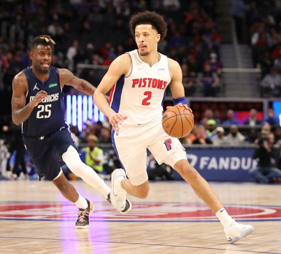 Detroit Pistons guard Cade Cunningham drives past Dallas Mavericks forward Reggie Bullock during the first quarter Wednesday, April 6, 2022, at Little Caesars Arena.