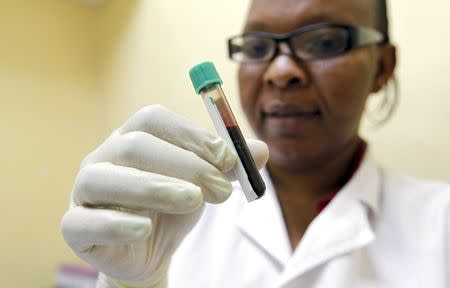 Mishi Mohammed, a phlebotomist, holds a blood sample from a woman to test for HIV at the Mater Hospital in Kenya's capital Nairobi, September 10, 2015. REUTERS/Thomas Mukoya