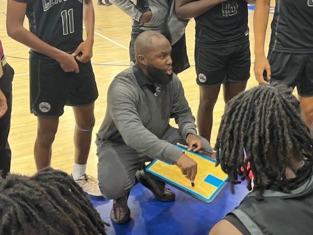 Palm Beach Central coach John St. Juste diagrams a play during a timeout.