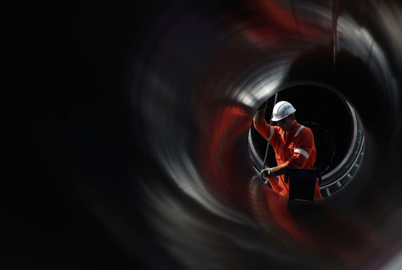 FILE PHOTO: A worker is seen through a pipe at the construction site of the Nord Stream 2 gas pipeline in Russia