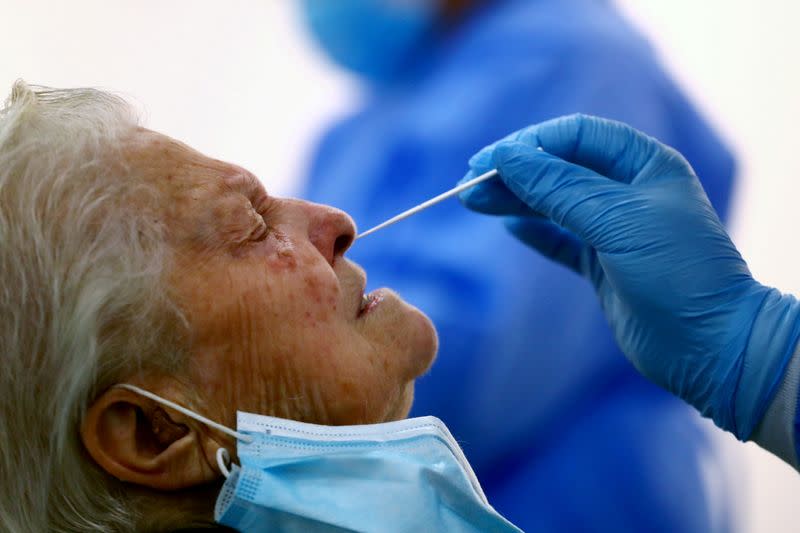 FILE PHOTO: A woman has a swab sample taken for a coronavirus disease (COVID-19) antigen test in Madrid