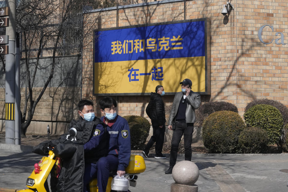 A sign outside the Canadian Embassy showing the Ukraine flag reads "We stand together with Ukraine" on Thursday, March 3, 2022, in Beijing. China on Thursday denounced a report that it asked Russia to delay invading Ukraine until after the Beijing Winter Olympics as "fake news" and a "very despicable" attempt to divert attention and shift blame over the conflict. (AP Photo/Ng Han Guan)