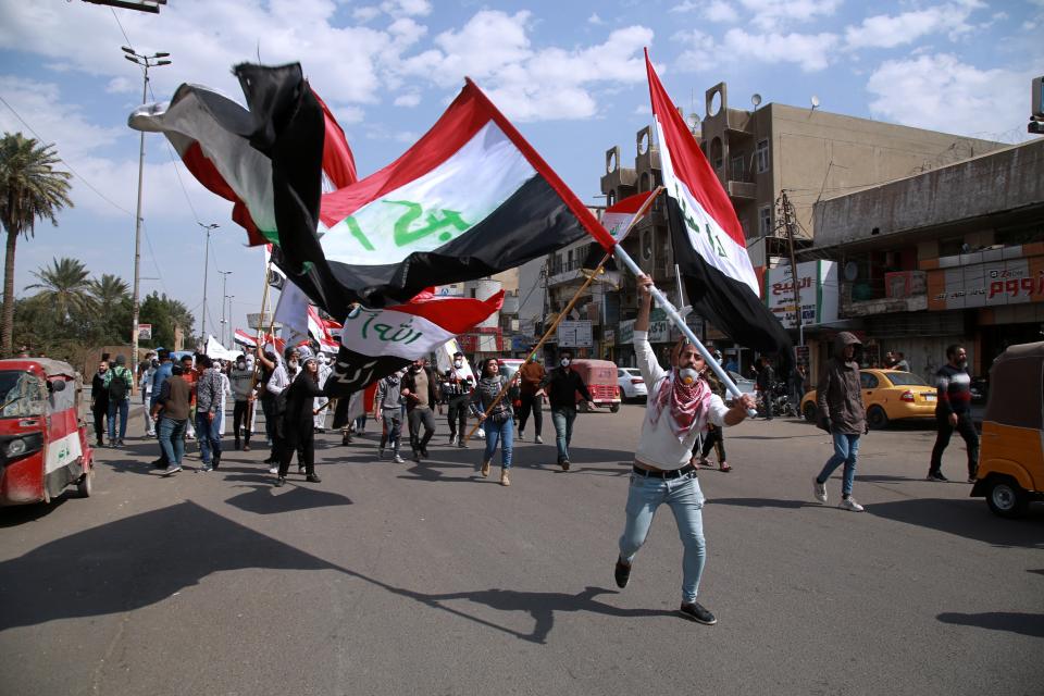 Anti-government protesters wave Iraqi flags in Baghdad, Iraq, Sunday, March 1, 2020. Iraqi student protesters converged on Baghdad's Tahrir Square, the epicenter of the five-month- anti-government protest movement, to voice their rejection of the country's proposed new prime minister. (AP Photo/Khalid Mohammed)