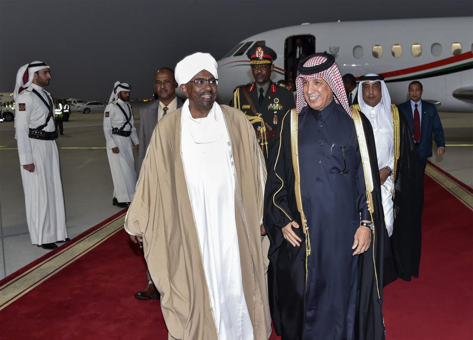 In this Tuesday, Jan. 22, 2019 handout photo from Qatar News Agency, Sudanese President Omar al-Bashir, center left, and his delegation are greeted by Qatari officials at Hamad International Airport, Doha Qatar. Sudan's embattled president is in Qatar looking for support amid weekslong protests against his 29-year rule in the African nation. Al-Bashir will meet Wednesday with Qatar's ruling emir, Sheikh Tamim bin Hamad Al Thani. The two men are expected to discuss possible aid to Sudan, which is suffering from deep economic problems that sparked the protests. (Qatar News Agency via AP)