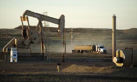 A service truck drives past an oil well on the Fort Berthold Indian Reservation in North Dakota, November 1, 2014. REUTERS/Andrew Cullen