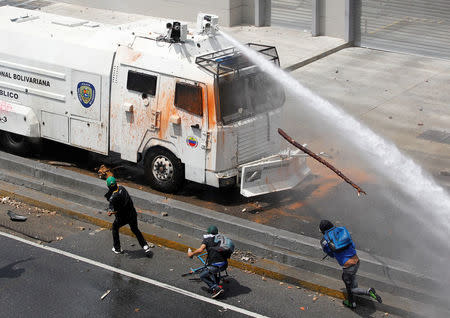 A police water cannon disperses demonstrators during an opposition rally in Caracas, Venezuela. REUTERS/Christian Veron