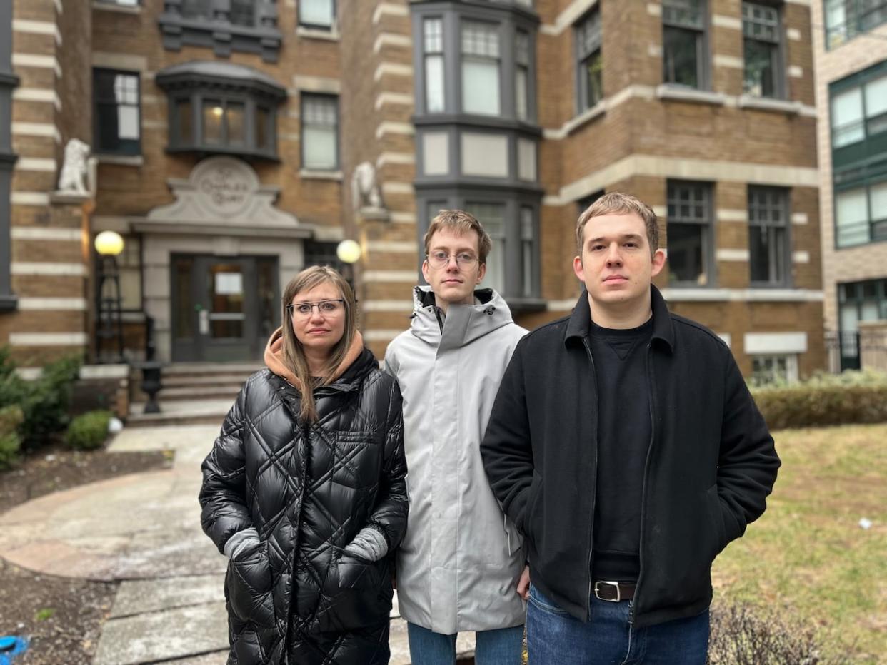 Tanya Osmond, Justin Cowen and David Holysh stand in front of their apartment building in Toronto's Church-Wellesley neighbourhood. The building has been without heat and hot water since Dec. 19.  (Ryan Patrick Jones/CBC  - image credit)