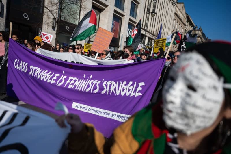 Participants stand on the street Unter den Linden during a demonstration for International Women's Day and hold a banner with the slogan "Class Struggle Is Feminists' Struggle". Several more demonstrations and rallies are planned in the capital until the evening. Christophe Gateau/dpa