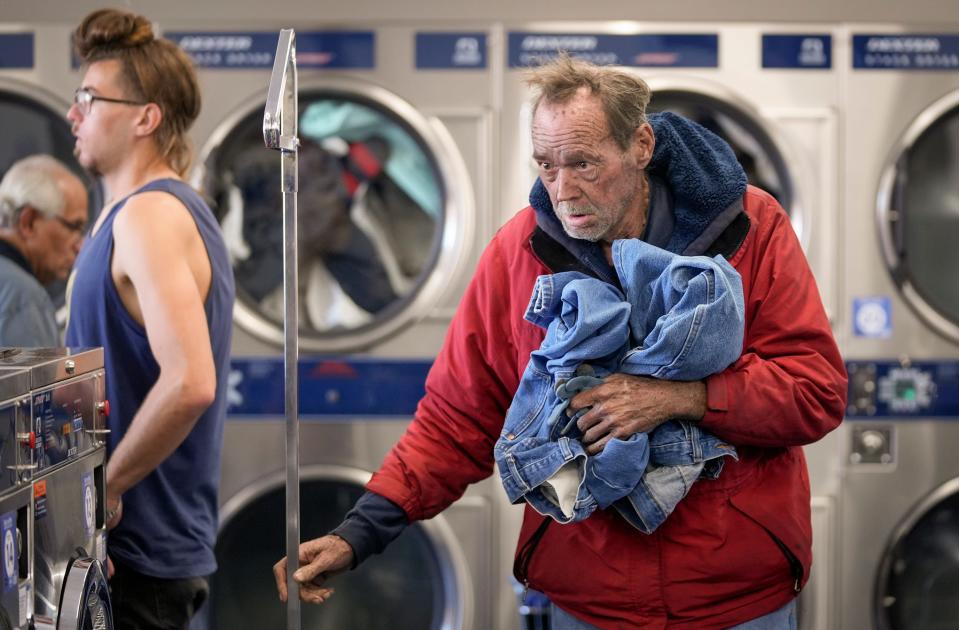 Carl Hedges does his laundry at the Clean Laundry laundromat during the Maximizing Hope event Jan. 29. The nonprofit is now putting the laundry events on hold for a few months so caseworkers can focus on resolving the needs of their existing clients.