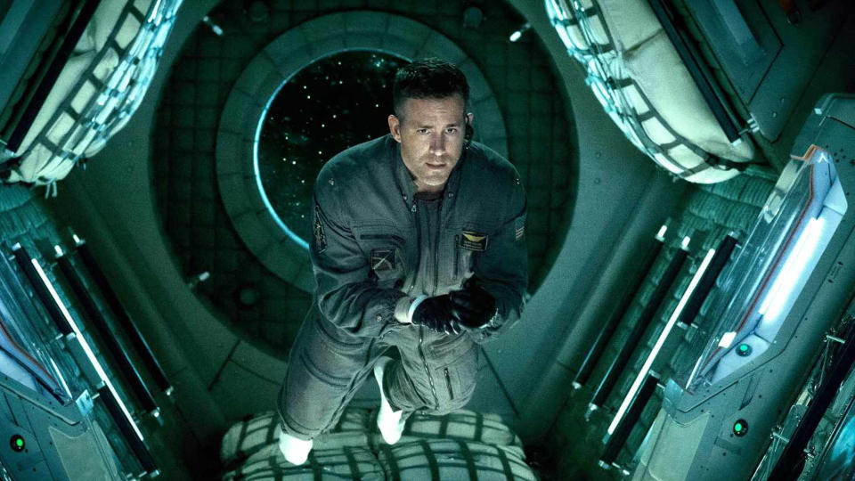 Ryan Reynolds floating in the hallway of a space station in 