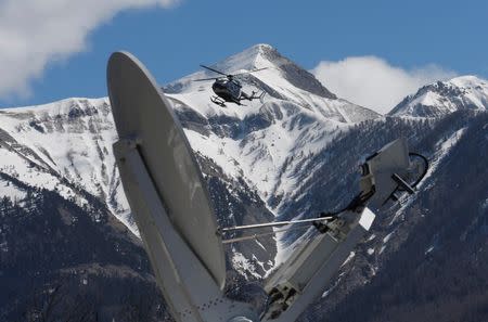 A rescue helicopter from the French Gendarmerie lands behind a media satellite dish seen during operations near the crash site of an Airbus A320, in Seyne-les-Alpes, March 26, 2015. REUTERS/Jean-Paul Pelissier