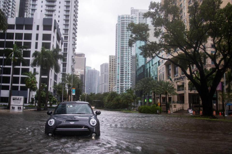 A MINI Cooper sits abandoned on the flooded intersection of Southwest 13th Street and Brickell Avenue due to Tropical Storm Eta in Miami, Florida, Monday, Nov. 9, 2020